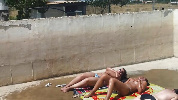 Blondīne un brunete ķircina viena otras slapjās incītis lūpas uz dīvāna